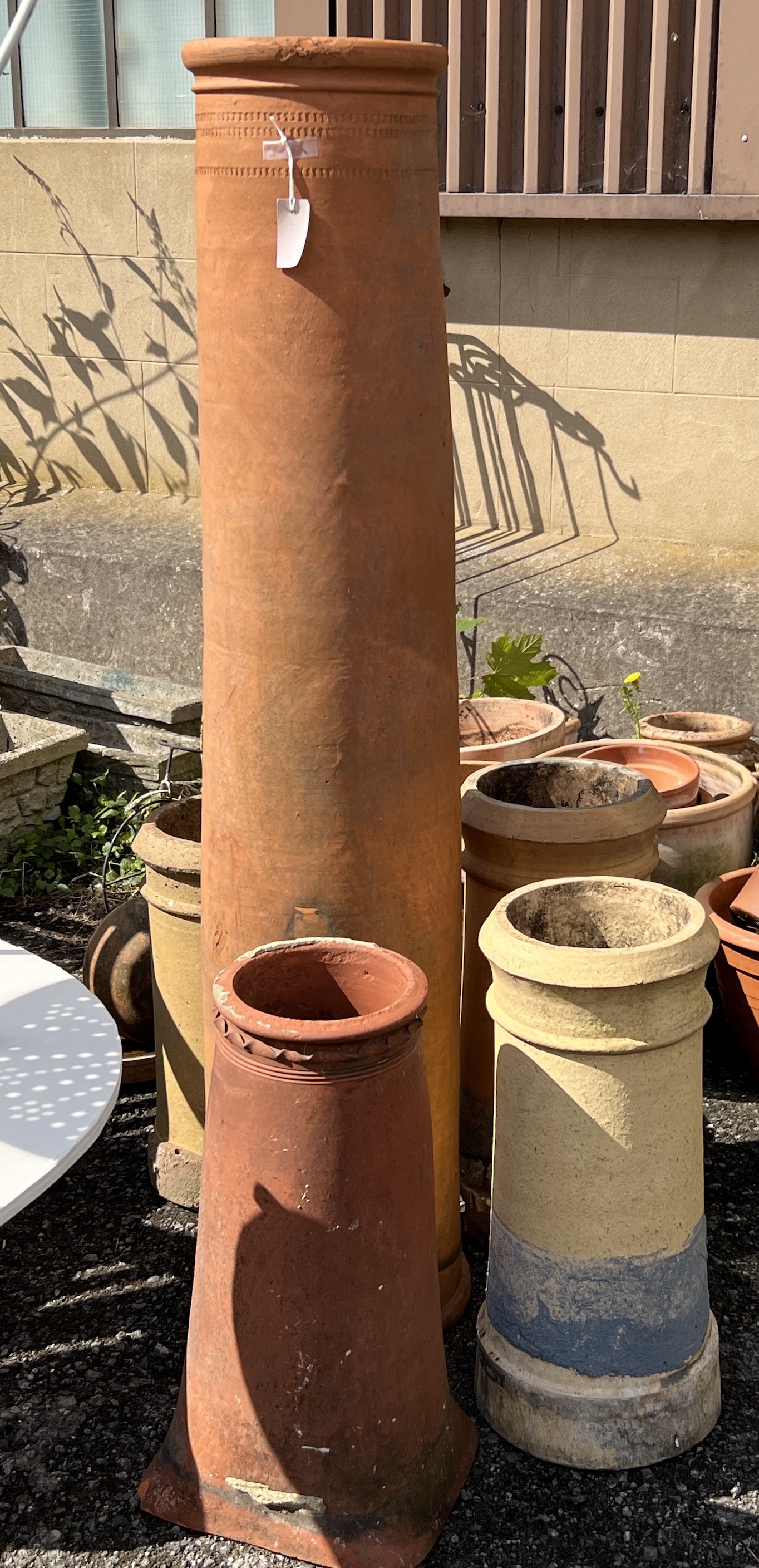 Five terracotta and earthenware chimney pots, largest height 154cm